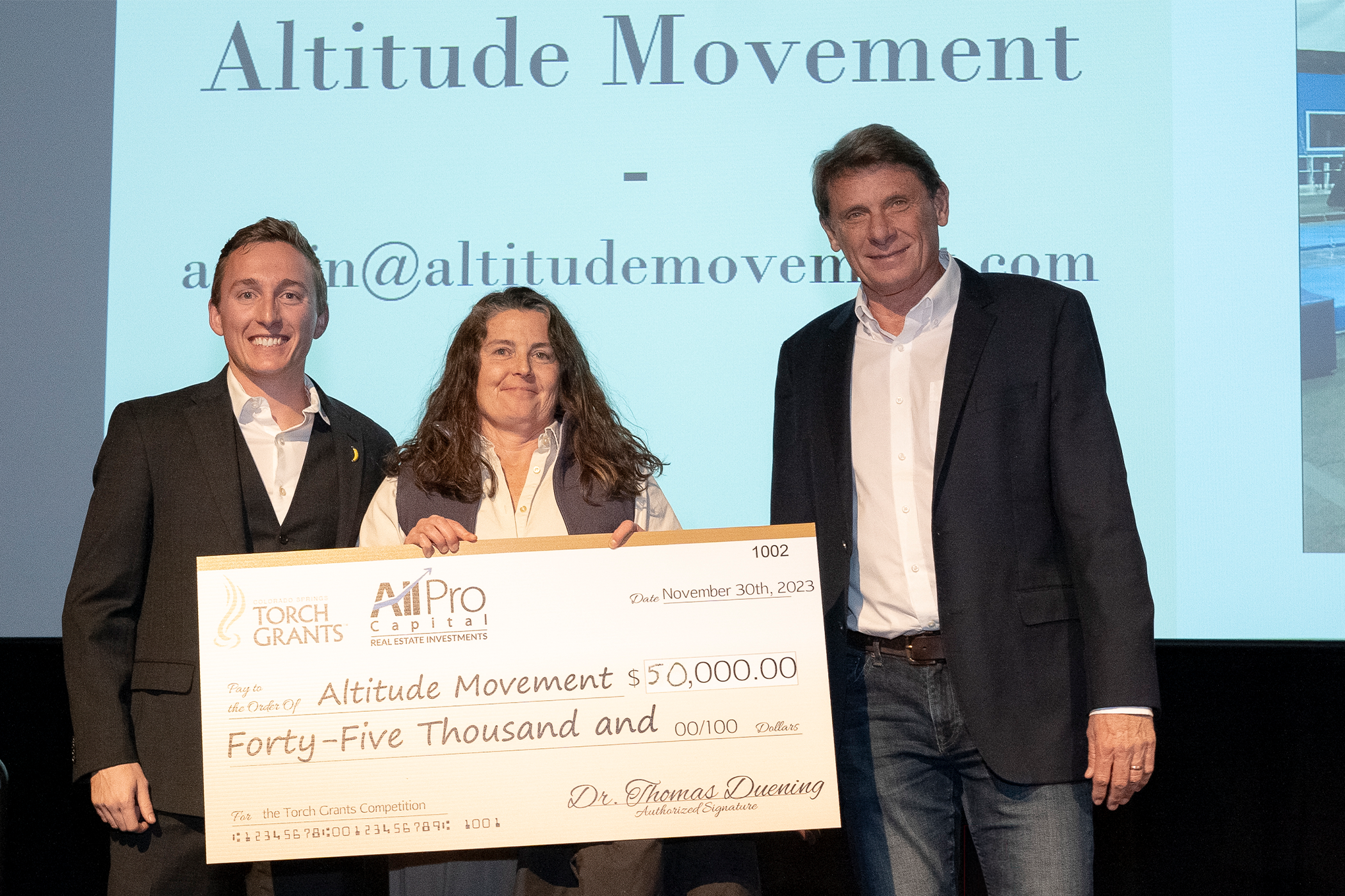 Michelle from Altitude Movement holding her torch grant check